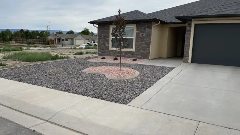 Concrete curbing around a rock landscape bed on a Western Colorado property.