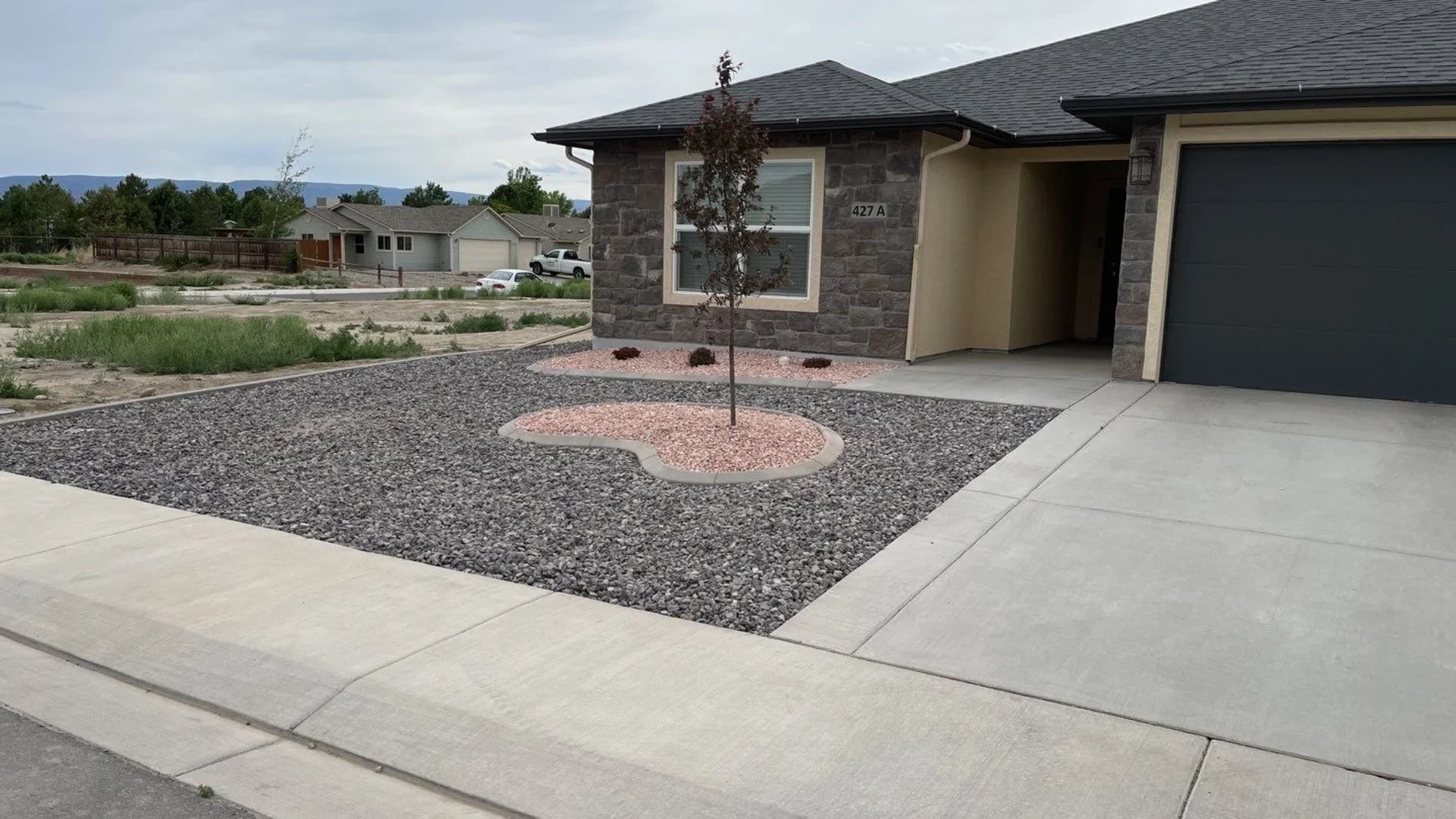 Concrete curbing around a rock landscape bed on a Western Colorado property.