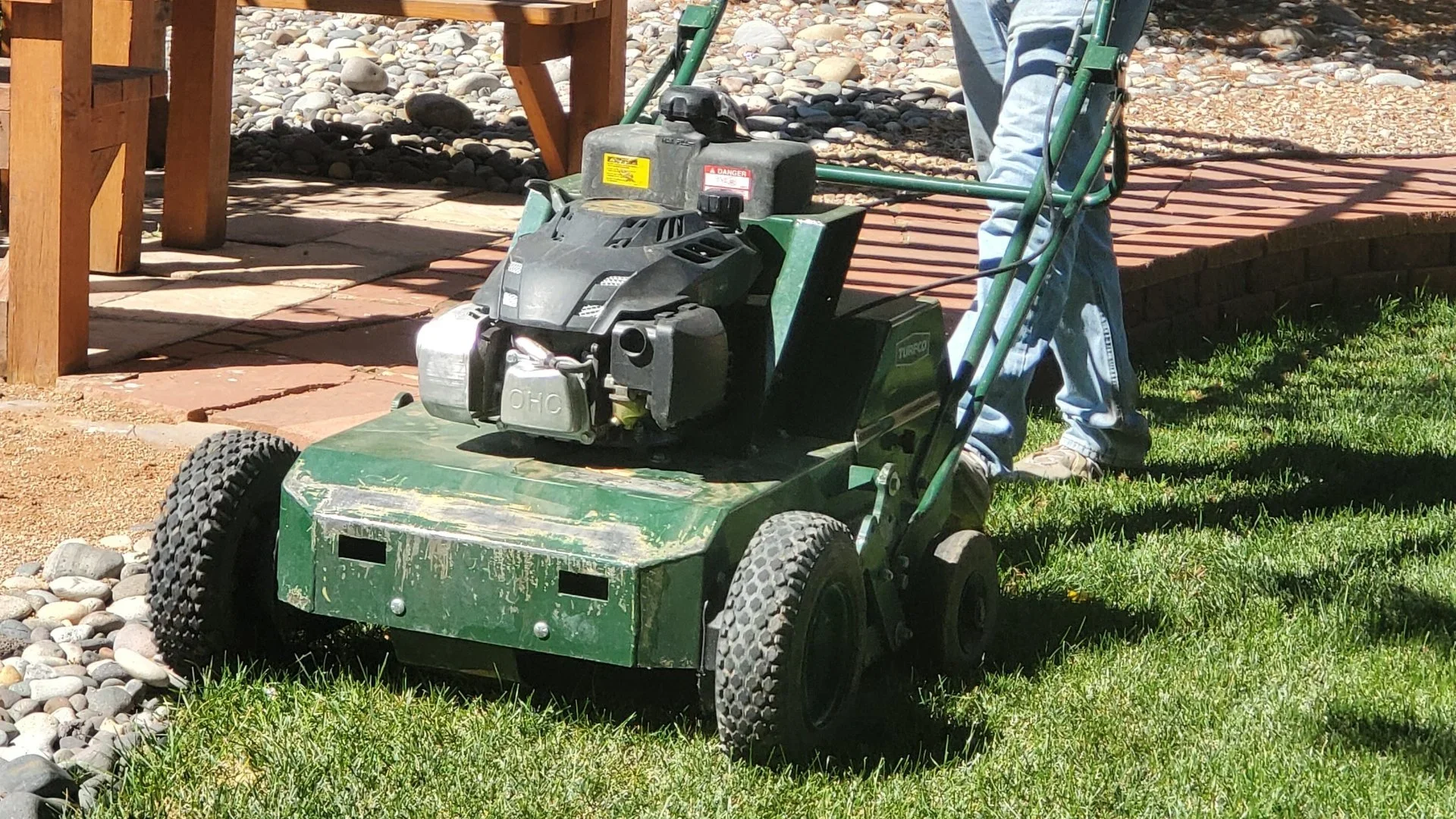 Crew maintaining landscape equipment near mature trees in Western Colorado.