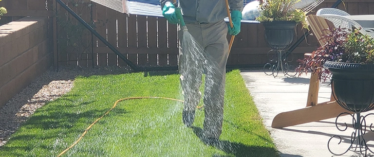 Worker in green jacket trimming plants in Grand Junction, CO.