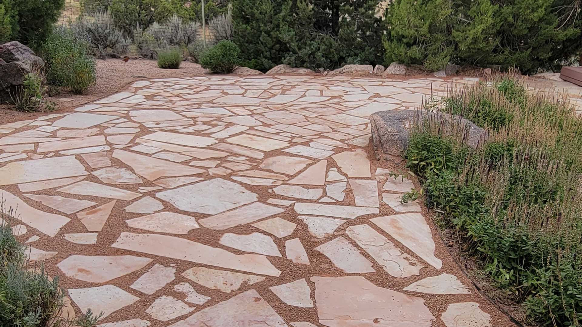 A new flagstone patio with perfect landscaping around it.