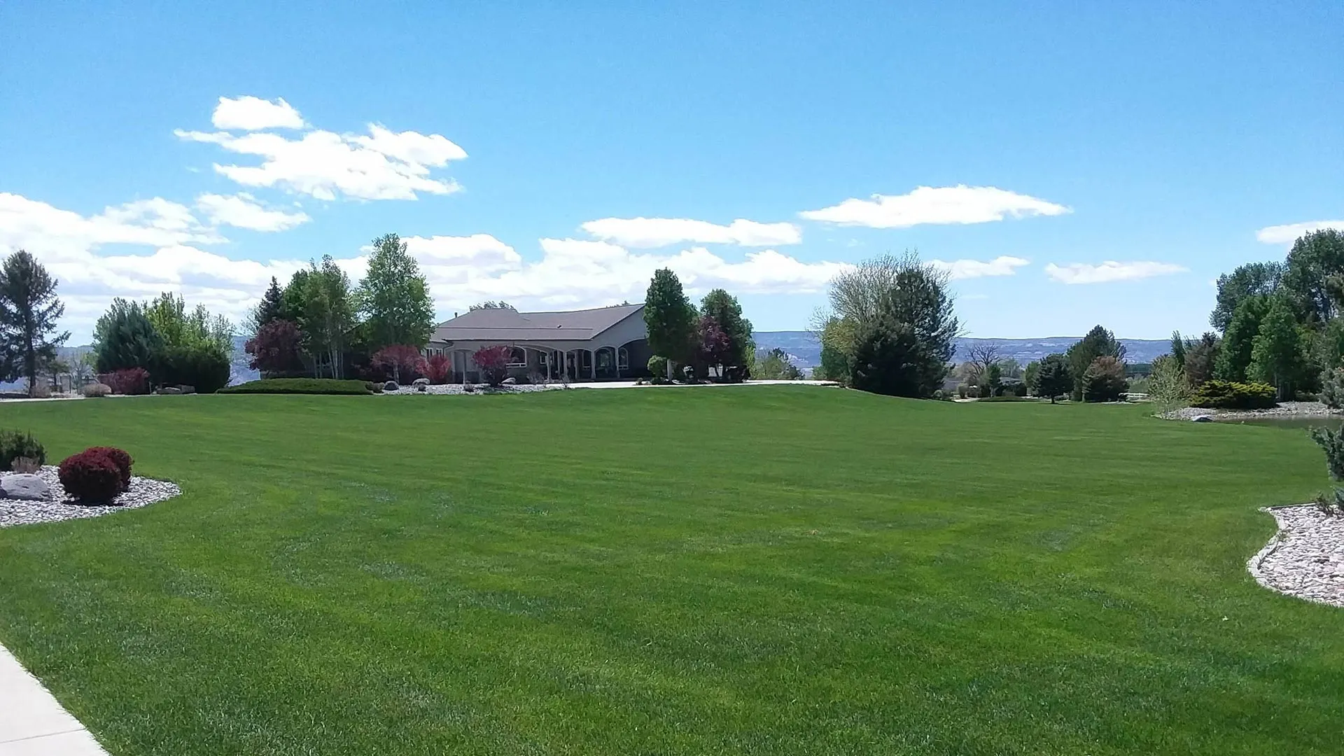 A healthy, beautiful lawn with a lovely home in the background in the Grand Junction Area.