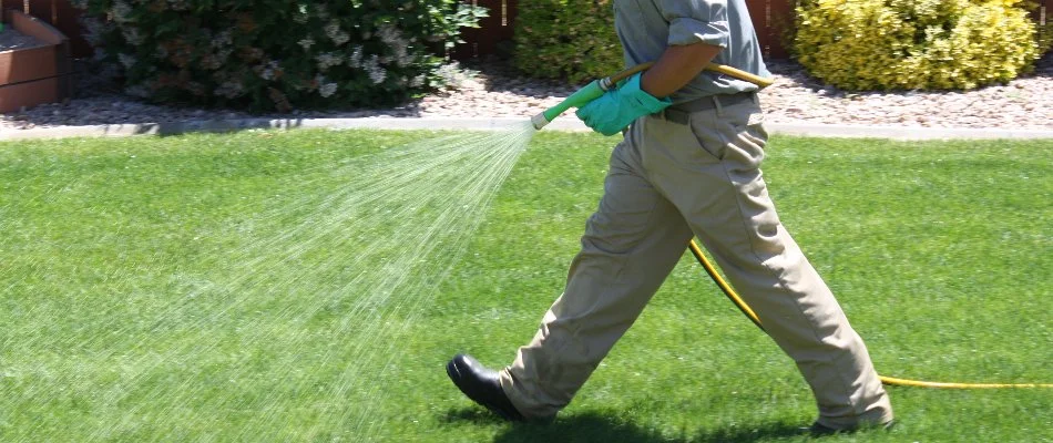 Tech spraying liquid fertilizer on a lawn in Grand Junction, CO.