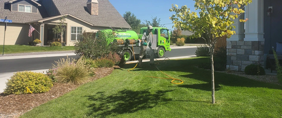 Lawn care professional treating lawn in Loma, CO.