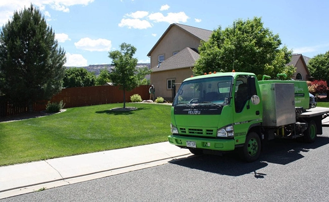 A Mesa Turf Masters employee is checking his landscape work with his truck in the street.
