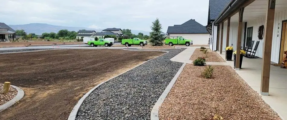 New landscape beds and yard renovation in progress near green trucks in Grand Junction, CO.